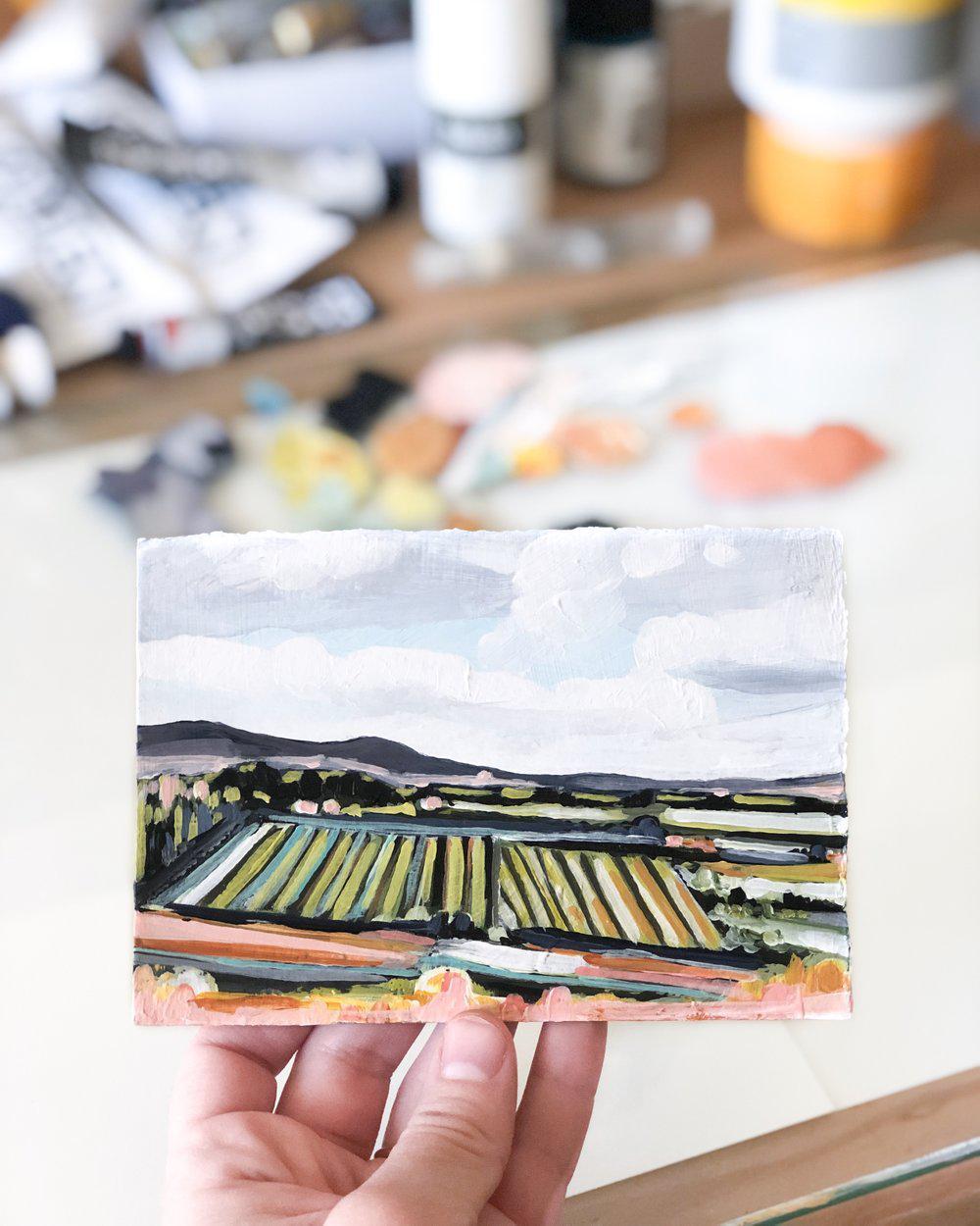 Abstract landscape painting held in hand.