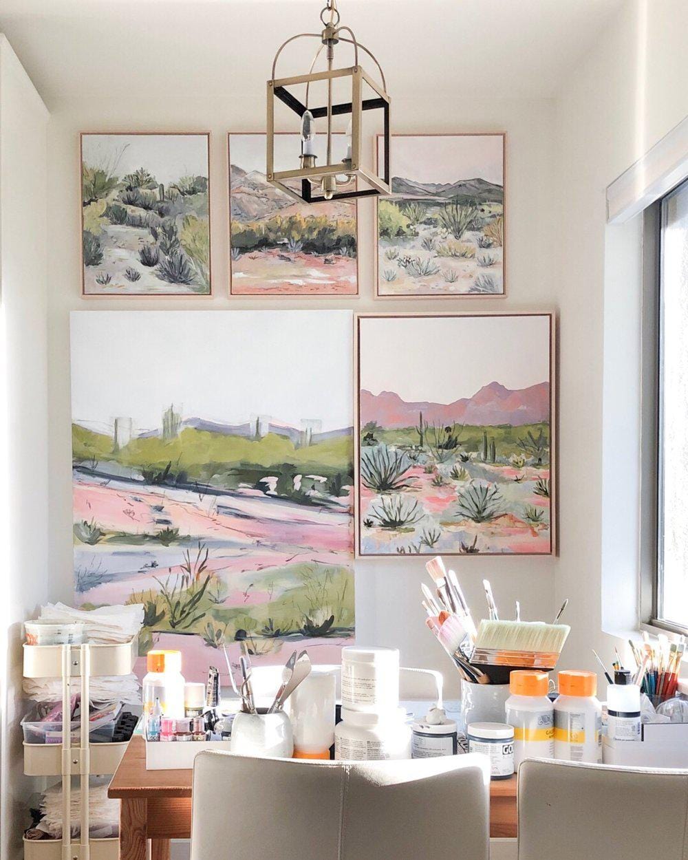 Paintings and art supplies on a wall.