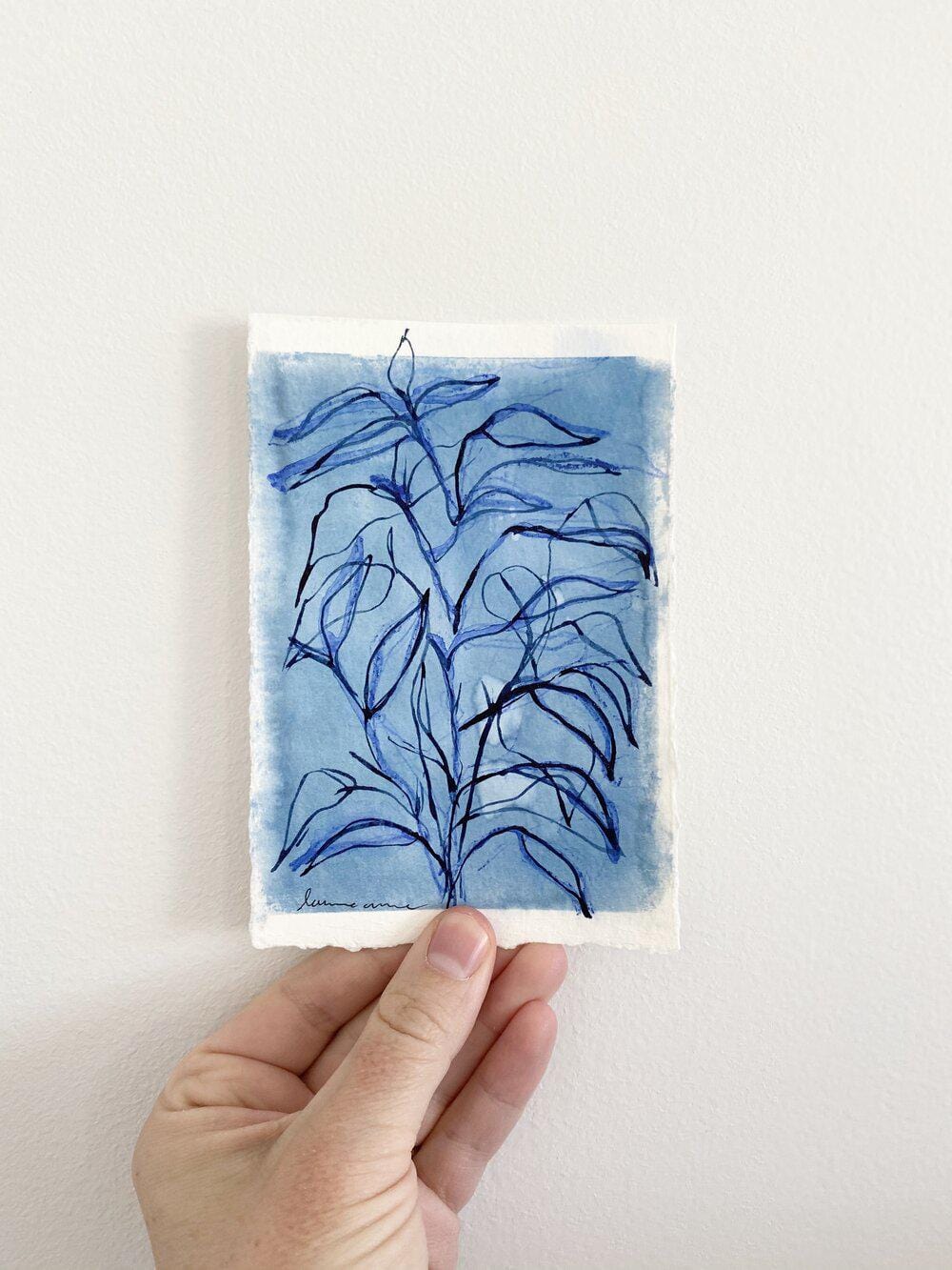 Blue plant sketch held in hand
