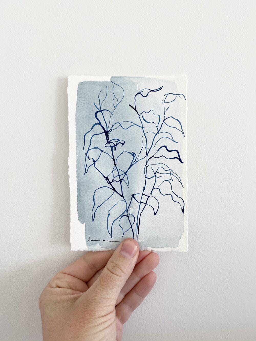 Hand holding watercolor plant art