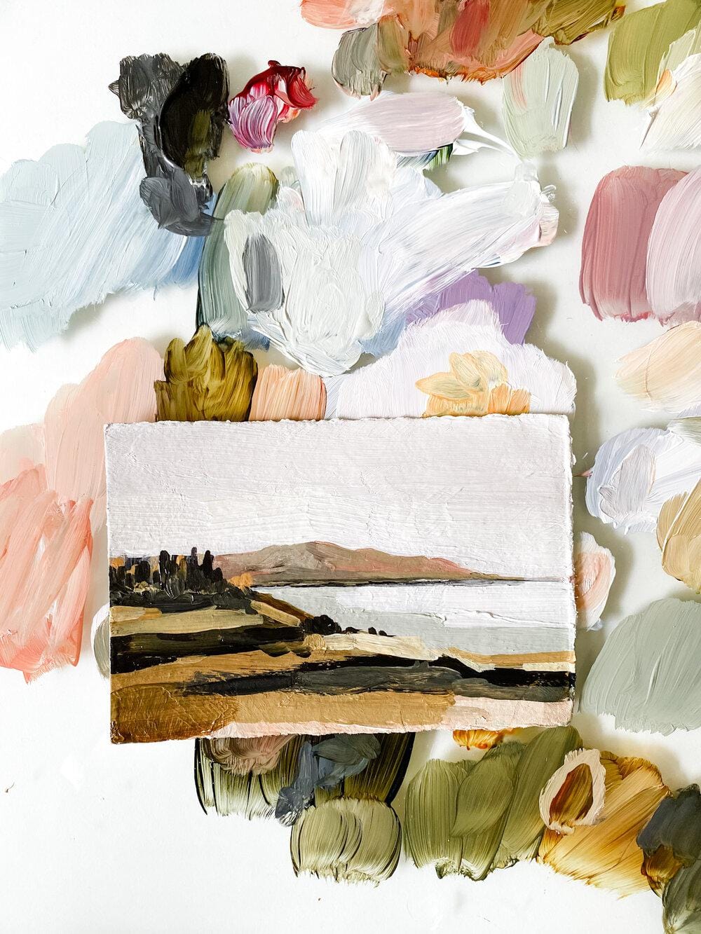 Landscape painting surrounded by paint swatches.