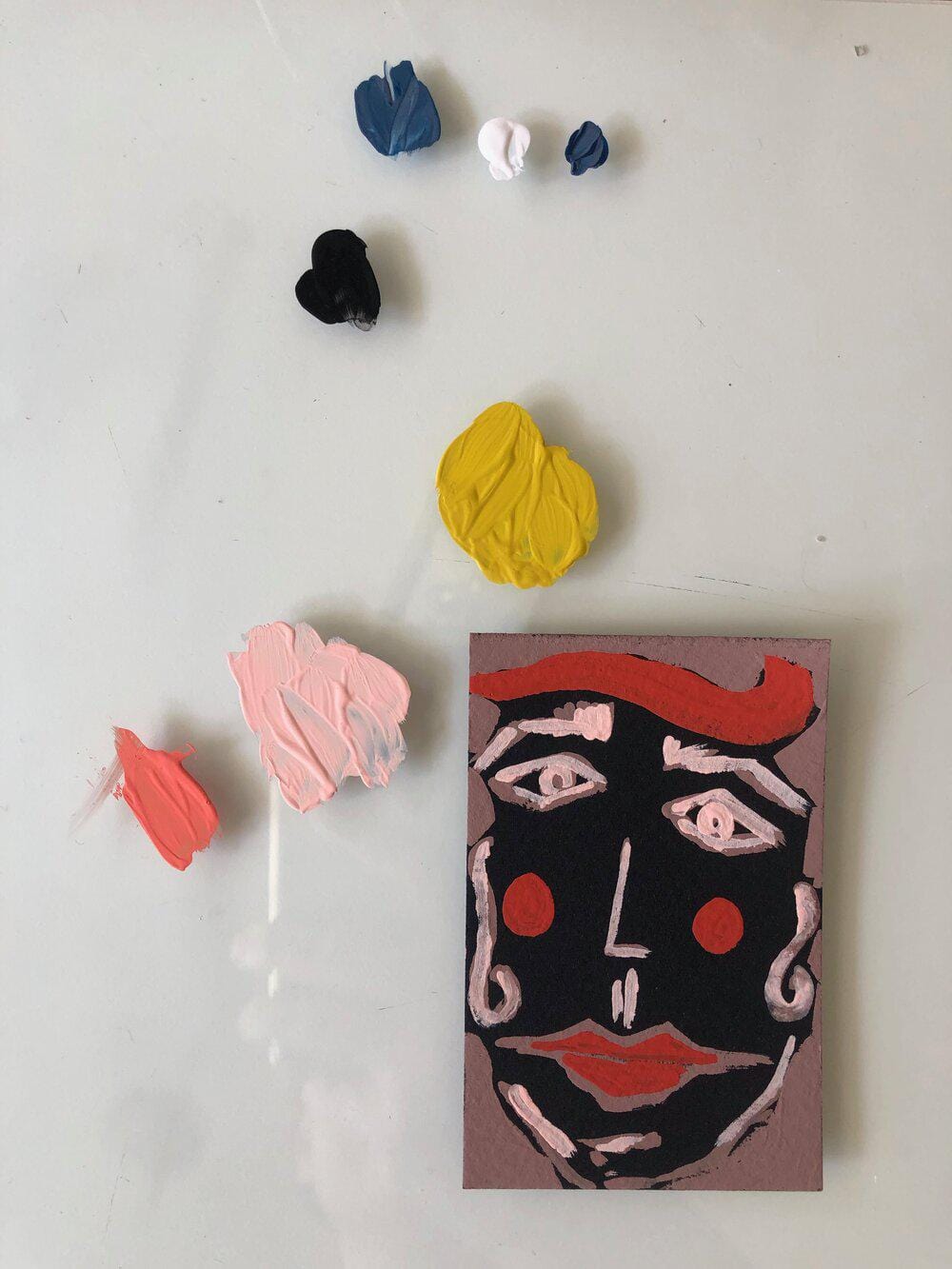 Painted face with colorful paint splotches.