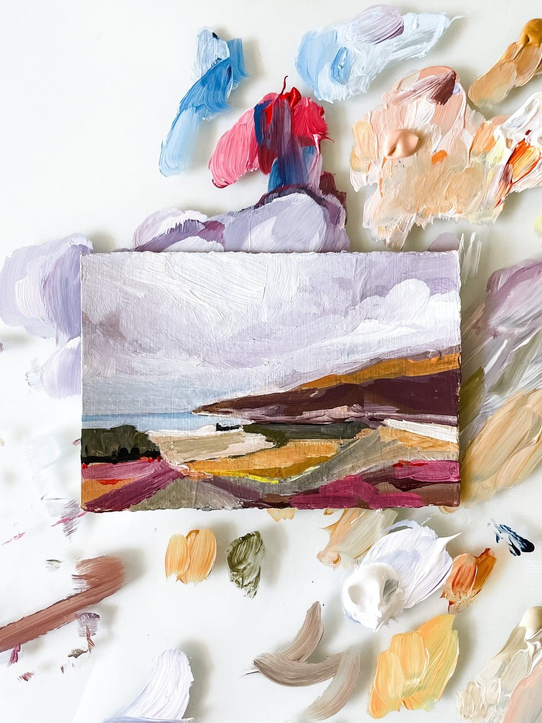 Landscape painting with surrounding paint swatches.
