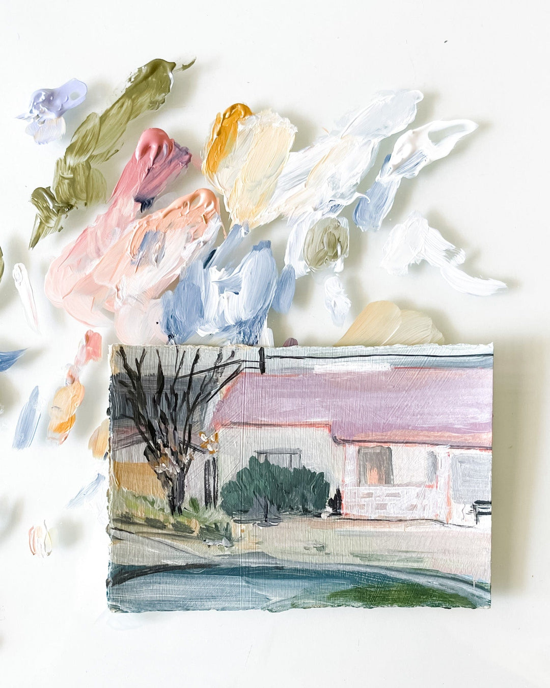 Painting of a house with a palette of colorful paint.