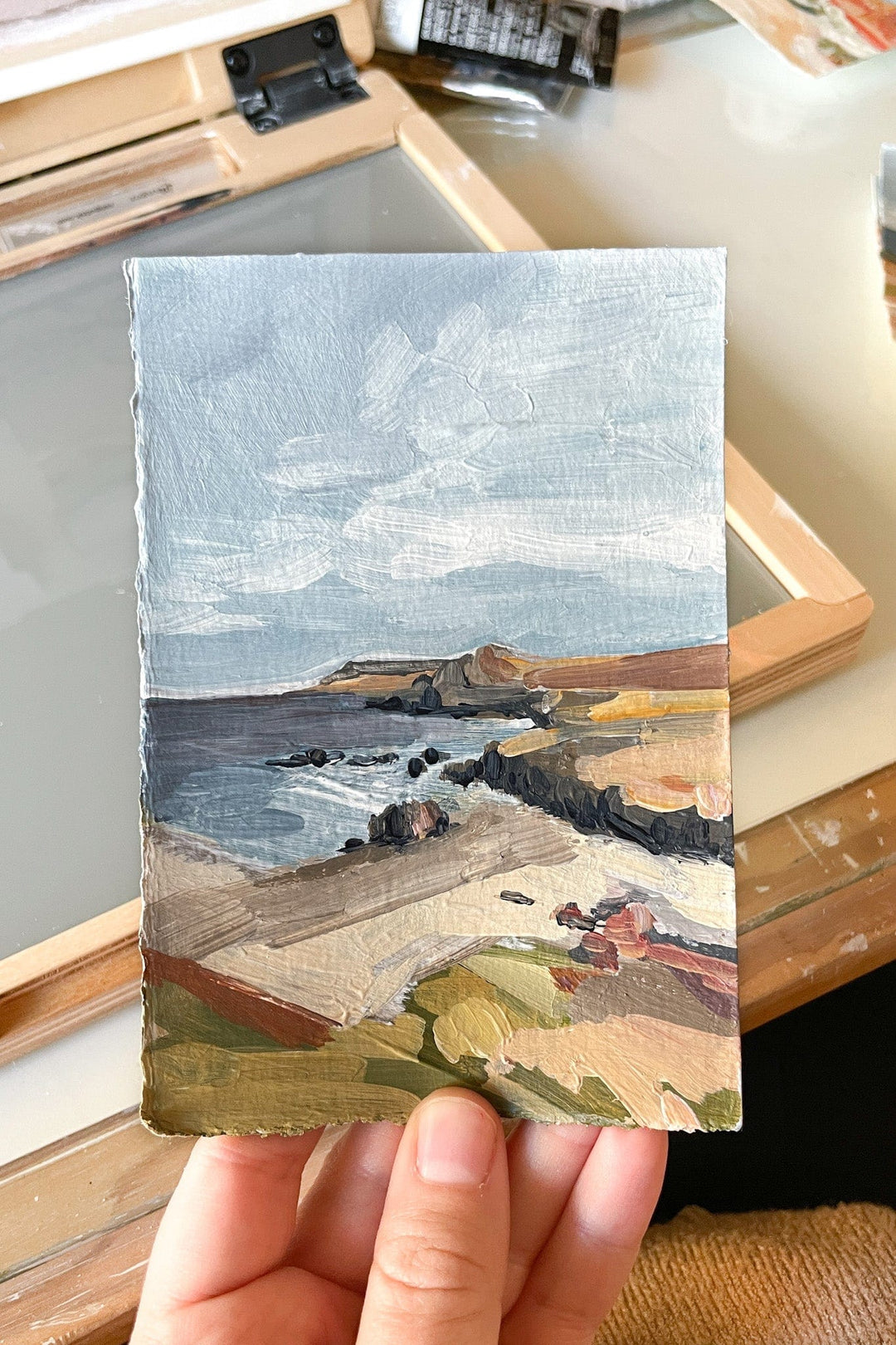 Miniature landscape painting of a coastline.