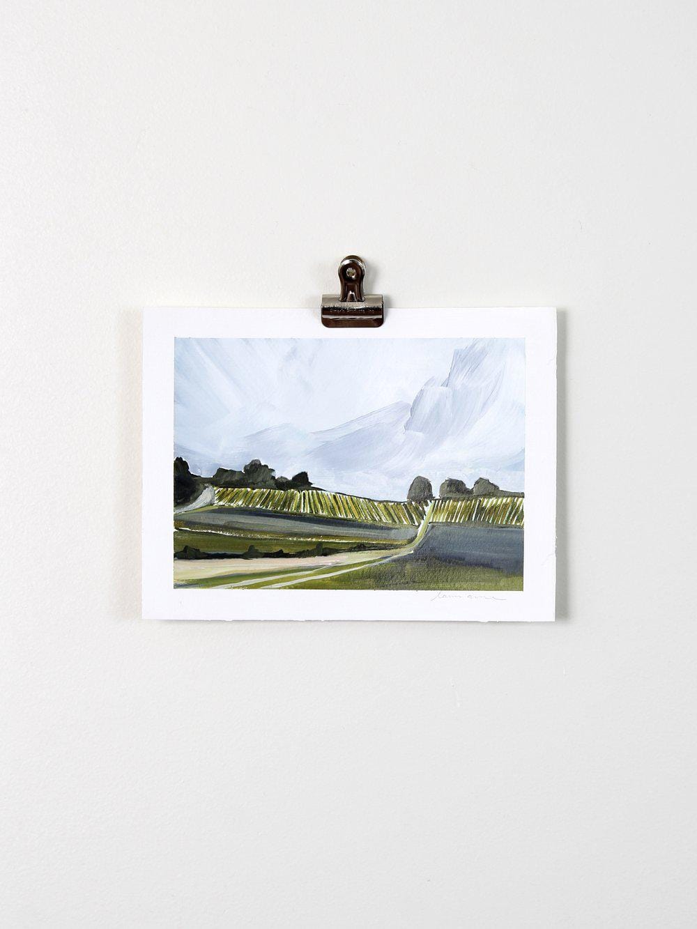 Landscape painting print clipped to wall.