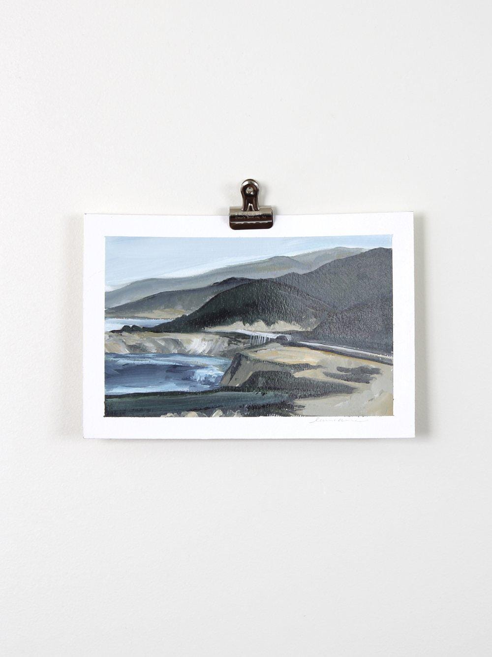 Mountain landscape painting clipped to wall.