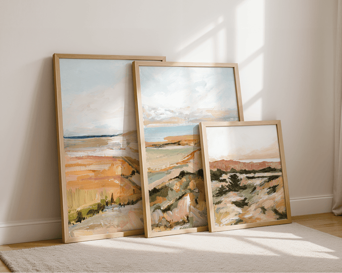 3 art prints leaning on a wall