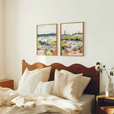 Bedroom with wooden headboard, pillows, and two framed landscape paintings on the wall.