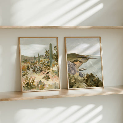 Two framed artworks on a shelf with a neutral background